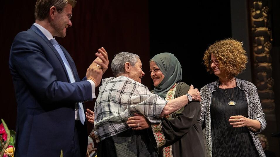 Die Preisträgerinnen freuen und umarmen sich.