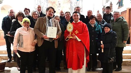 Schirmherr Moritz Graf von Deym (vorne, ab 2. v. l.)mit der Urkunde von Bischof Oster, Pfarrer Michael Osterholzer mit der Reliquie des Sebastian und Pfarrgemeinderatsvorsitzende Heidi Attenberger mit den Mitgliedern