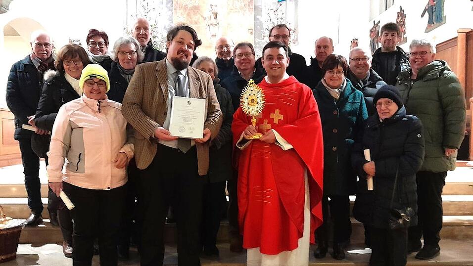 Schirmherr Moritz Graf von Deym (vorne, ab 2. v. l.)mit der Urkunde von Bischof Oster, Pfarrer Michael Osterholzer mit der Reliquie des Sebastian und Pfarrgemeinderatsvorsitzende Heidi Attenberger mit den Mitgliedern
