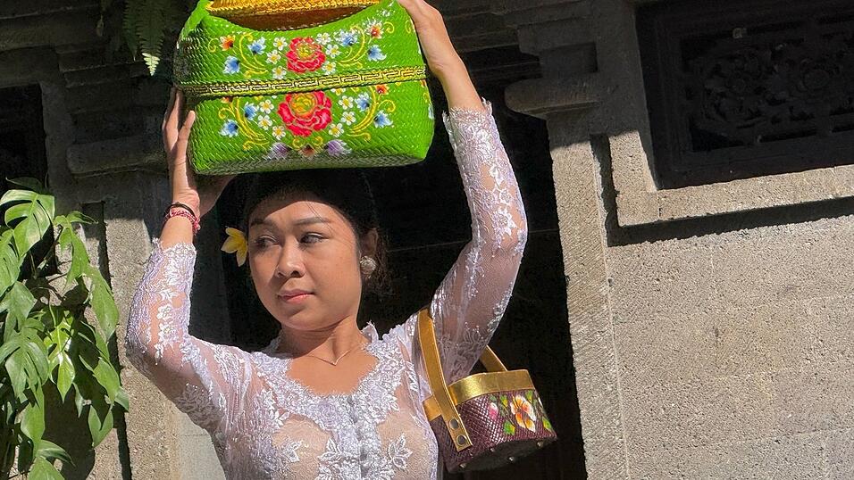 Viele Frauen balancierten bunte Flechtkörbe mit Opfergaben auf dem Kopf. Viele Frauen balancierten bunte Flechtkörbe mit Opfergaben auf dem Kopf.