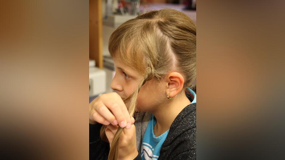 1. Leonie bindet ihre Haare zun&auml;chst mit einem Gummi zu einem Pferdeschwanz auf mittlerer H&ouml;he zusammen. An der Seitenpartie l&auml;sst sie eine dickere Str&auml;hne aus, diese wird sp&auml;ter gekordelt.