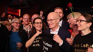 Peter Tschentscher (M.), Erster Bürgermeister von Hamburg, steht mit Rosen in der Hand bei der SPD-Wahlparty nach der Wahl zur Bürgerschaft auf der Bühne.