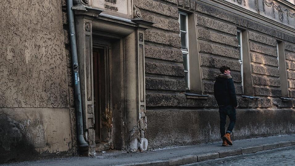 In einer kleinen Seitengasse entdeckt Jana ein heruntergekommenes Eingangstor, vor dem Bastian auf und ab gehen soll, während sie ihn fotografiert. 'Sogenannte ‚Lost Places' sind auf jeden Fall ein cooler Hintergrund. Das gibt jedem Foto ein bisschen Mystik', sagt sie. Doch das ist zum Teil auch sehr riskant: 'Bilder auf Bahngleisen zu machen, ist zum Beispiel richtig gefährlich! Wenn ich mir nicht hundertprozentig sicher bin, dass das Gleis stillgelegt ist, würde ich da niemals draufgehen.'