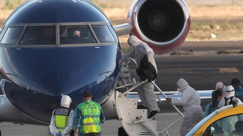 Die Passagiere betraten in Schutzkleidung das Flugzeug.