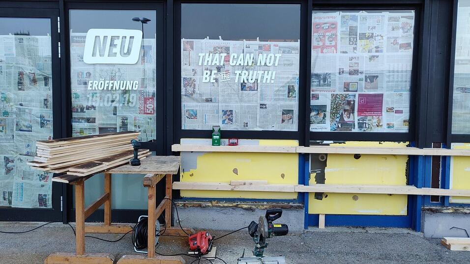 Bretter und Farbe verdecken das Blau des ehemaligen Baumarktes.