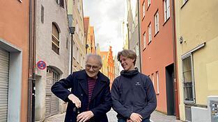 Lachen über einen Scherz: Der frühere Lehrer Hermann Stieß (l.) und dessen Retter, Schüler Uli Huber, beide aus der Gemeinde Kumhausen, kamen zum Foto in die Landshuter Ländgasse. Mit der Gehhilfe deutete Stieß zuvor ein Gewehr an und zielte imaginär auf den Fasan, der 2023 einen schweren Fahrradunfall des Pensionisten verursachte. Lachen über einen Scherz: Der frühere Lehrer Hermann Stieß (l.) und dessen Retter, Schüler Uli Huber, beide aus der Gemeinde Kumhausen, kamen zum Foto in die Landshuter Ländgasse. Mit der Gehhilfe deutete Stieß zuvor ein Gewehr an und zielte imaginär auf den Fasan, der 2023 einen schweren Fahrradunfall des Pensionisten verursachte.