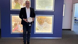 Der Leiter des Infineon-Standorts Regensburg, Jürgen Winterer, hält einen Wafer in der Hand. Wafer sind in der Halbleiterindustrie das Ausgangsmaterial für die Herstellung von Mikrochips und anderen elektronischen Komponenten.