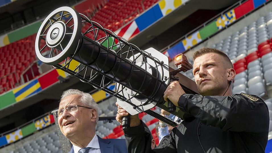 Bayerns Innenminister Joachim Herrmann (CSU) sieht zu, wie ein Polizist mit einem Störsender eine Drohne zur kontrollierten Landung bringt. (Archiv) Bayerns Innenminister Joachim Herrmann (CSU) sieht zu, wie ein Polizist mit einem Störsender eine Drohne zur kontrollierten Landung bringt. (Archiv)