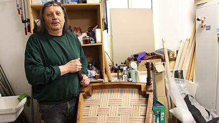 Dieser Sessel, dem der Polsterer Josef Wagner zu neuem Leben verholfen hat, hat schon Einiges hinter sich, wie Spuren auf der Unterseite zeigen. Die neue Unterpolsterung hat Wagner aus geflochtenen Gurten gefertigt.