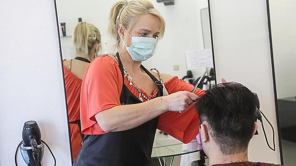 Mit Maske zum Friseur: An dieses Bild wird man sich wohl künftig gewöhnen müssen.