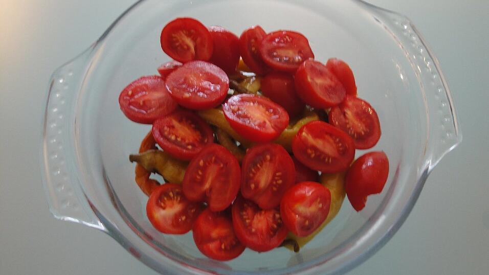Halbierte Tomaten ohne Strunk dar&uuml;ber geben.