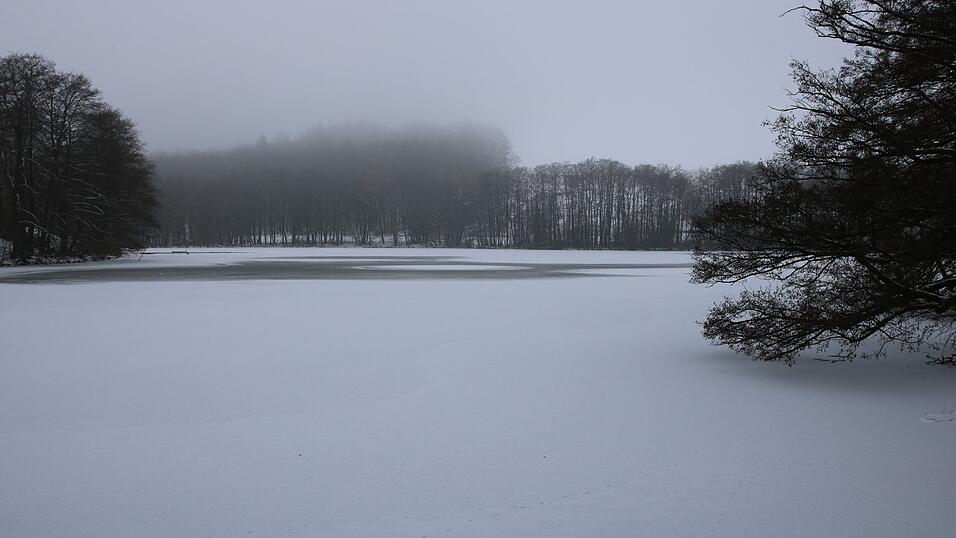 So sch&ouml;n wie ein gefrorener See ist, so gef&auml;hrlich kann es sein, sich auf das Eis zu wagen. Die dunklen Stellen verraten, dass die Eisdecke nicht geschlossen ist. Dick genug ist das Eis zudem auch nicht, wie hier auf dem Beckenweiher in der Gemeinde Wiesenfelden.