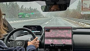 Andreas Wendt am Steuer des Testfahrzeugs. Hier erkl&auml;rt er, wie das induktive Laden funktioniert.