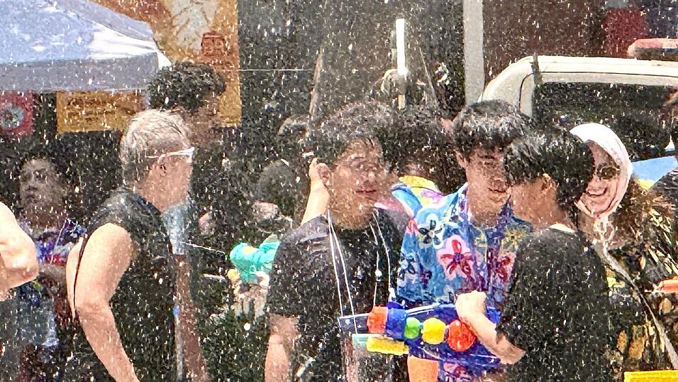 Einheimische und Touristen feiern traditionell zusammen - die meisten sind nach wenigen Minuten klatschnass.