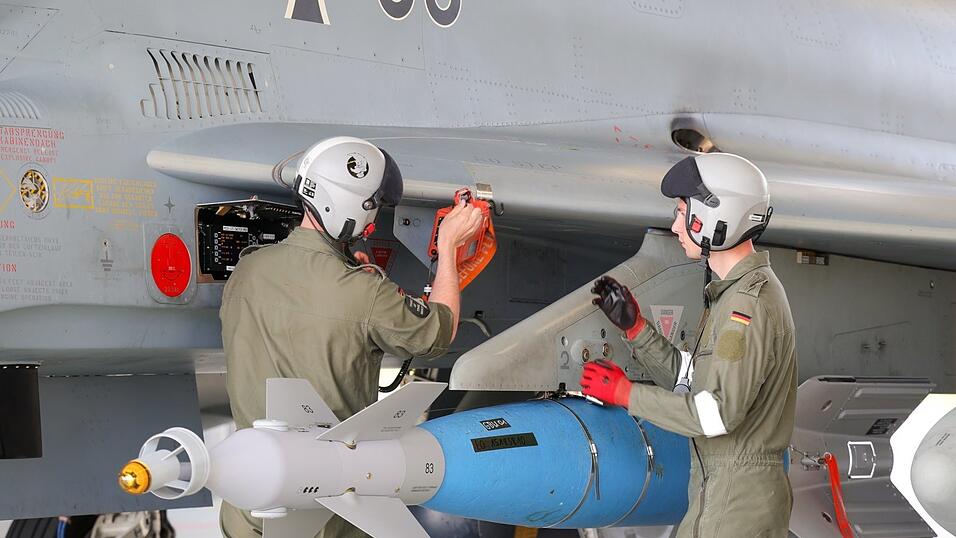 Eine Übungsbombe hängt an einem Eurofighter der Luftwaffe, zwei Mechaniker bereiten das Flugzeug für eine Übung vor. Wegen des russischen Angriffskriegs auf die Ukraine plant die Bundesregierung massiv in Aufrüstung zu investieren. Eine Übungsbombe hängt an einem Eurofighter der Luftwaffe, zwei Mechaniker bereiten das Flugzeug für eine Übung vor. Wegen des russischen Angriffskriegs auf die Ukraine plant die Bundesregierung massiv in Aufrüstung zu investieren.