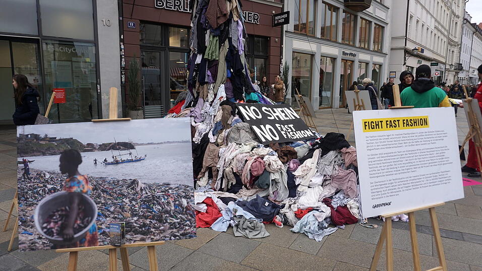 Die auf dem Neupfarrplatz aufgetürmten Kleider stammen aus Ghana. Die auf dem Neupfarrplatz aufgetürmten Kleider stammen aus Ghana.