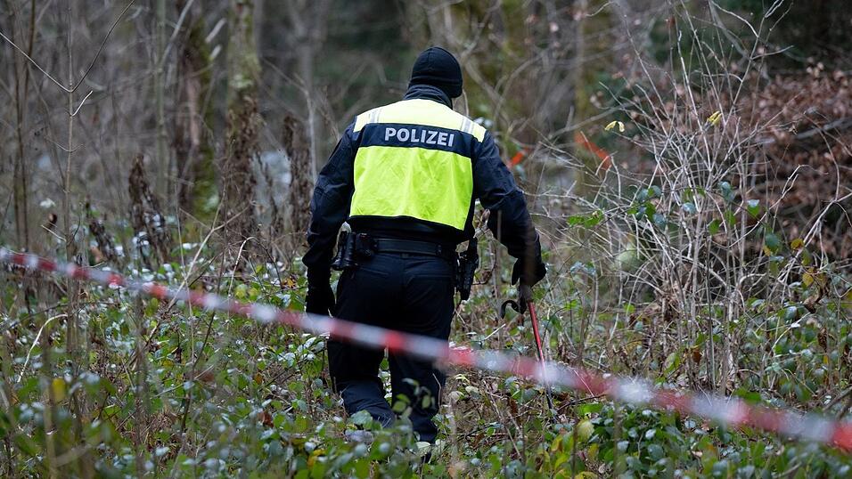 Ein Polizist nimmt an der Durchsuchung von einem Waldstück im Forstenrieder Park teil.
