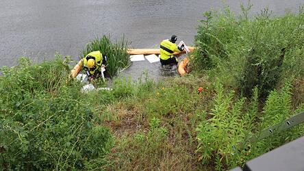Zwei Feuerwehrleute errichten am Überlauf des Regenrückhaltebeckens am Floßhafen Ölsperren. Zwei Feuerwehrleute errichten am Überlauf des Regenrückhaltebeckens am Floßhafen Ölsperren.
