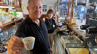 Orlando Paldino zeigt stolz eine Tasse Espresso für 70 Cent. Im Hintergrund steht seine Frau Rosina Furiati. Orlando Paldino zeigt stolz eine Tasse Espresso für 70 Cent. Im Hintergrund steht seine Frau Rosina Furiati.
