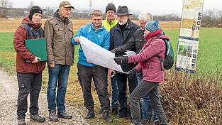 Besorgt blicken die Natursch&uuml;tzer von der gesch&uuml;tzten Streuwiese auf die benachbarte Fl&auml;che, auf der ein Masth&auml;hnchenstall gebaut werden soll.