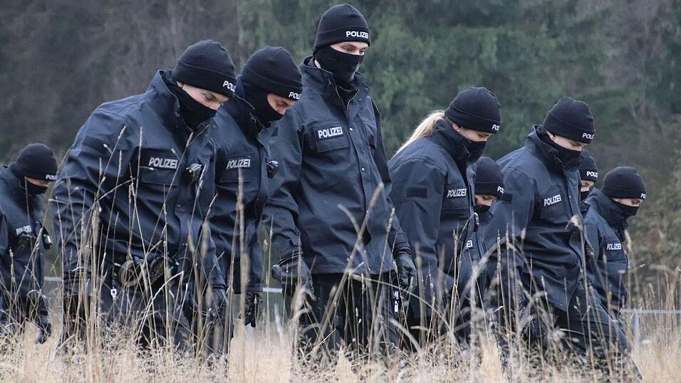 Polizeibeamte suchen auf einer Wiese Spuren, nachdem in der Nähe des Flughafens eine 16-Jährige tot aufgefunden worden ist. Polizeibeamte suchen auf einer Wiese Spuren, nachdem in der Nähe des Flughafens eine 16-Jährige tot aufgefunden worden ist.