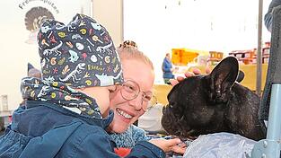 Die Wochenmarktbesucher Laura Seger und Sohn Leano sind ganz verliebt in Hund Buddy.