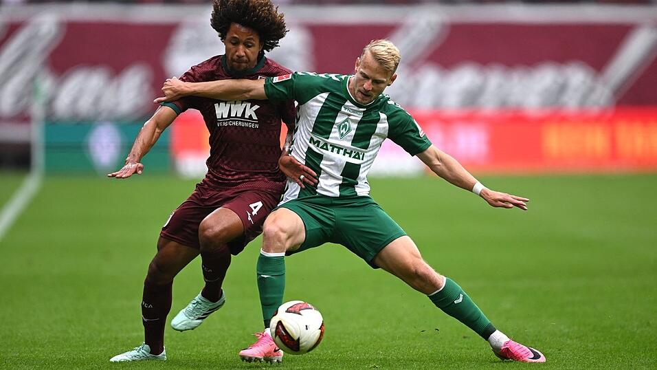 Im Zweikampf: Han-Noah Massengo vom FC Augsburg (l) und der Bremer Marco Grüll. Im Zweikampf: Han-Noah Massengo vom FC Augsburg (l) und der Bremer Marco Grüll.