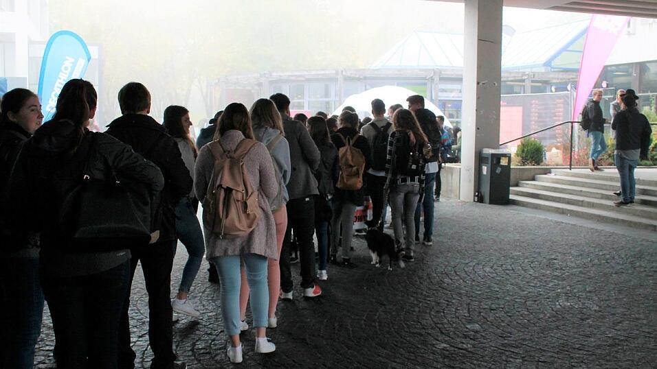 Schlange vor der Mensa - Die Studenten stehen jedoch nicht fürs Essen an, sondern weil neben dem Mensagebäude kostenlose Geschenketaschen verteilt werden. Schlange vor der Mensa - Die Studenten stehen jedoch nicht fürs Essen an, sondern weil neben dem Mensagebäude kostenlose Geschenketaschen verteilt werden.