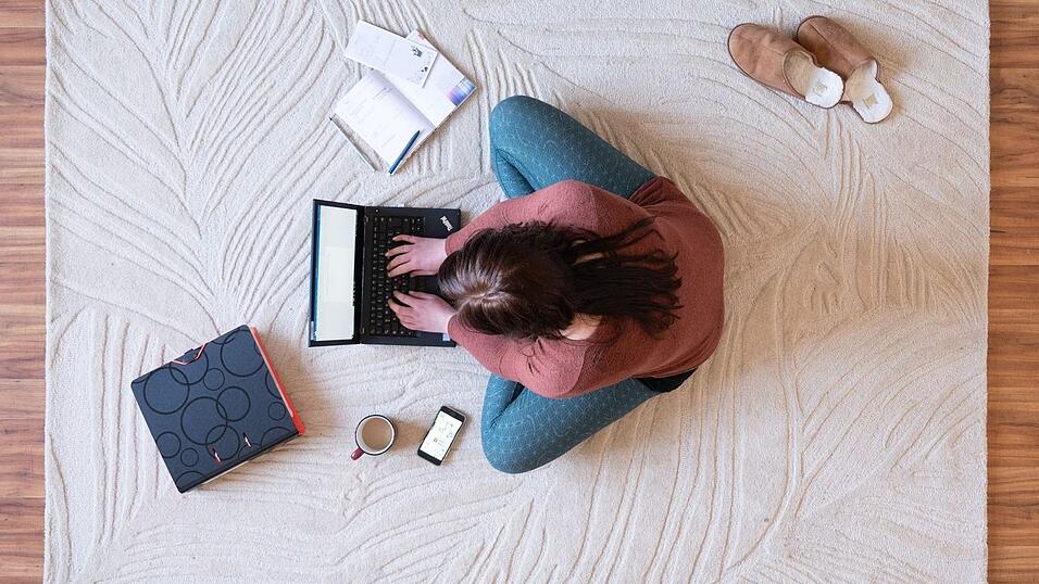 Eine Frau sitzt im Homeoffice am Laptop. Eine Frau sitzt im Homeoffice am Laptop.