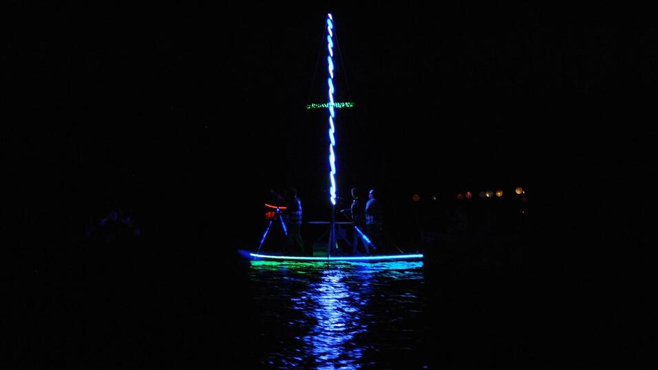 Bunt beleuchtete Boote fahren bei der Lampionfahrt über die Donau.