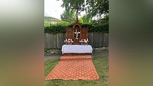 Der Altar ist dieses Jahr mit Pfingstrosen, einem Altartuch mit rosa Aufstickung und der Madonnen-Statue mit Jesuskind geschm&uuml;ckt.