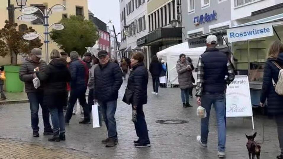 Trotz des Nieselwetters bummeln zahllose Besucher durch die Stra&szlig;en.