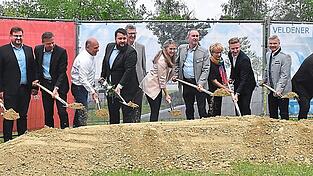 Vertreter des Generalunternehmers Bachl und des Bauherrn, Paul und Peter Ilmberger, Bürgermeisterin Sibylle Entwistle, Wirtschaftsminister Hubert Aiwanger, Monika und Peter Ilmberger jun., Landrat Peter Dreier und Architekt Josef Wiesmüller beim offiziellen Spatenstich am Rande des Baufelds.