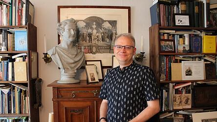 Marcus Spangenberg steht neben einer Büste von Ludwig II. in seinem Arbeitszimmer.