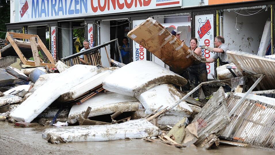 Helfer werfen am 5. Juni 2016 Matratzen auf einen Haufen vor einem Matratzengesch&auml;ft in Simbach am Inn. Die Schlammwelle zerst&ouml;rte viele Wohnungen, Gesch&auml;fte und deren Einrichtungen.