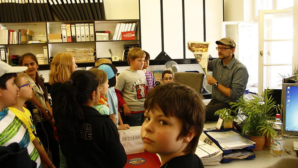 Als Abschluss besuchten die Schüler die Stadtredaktion in Straubing. Redakteur Ulli Scharrer beantwortete alle Fragen der Kinder. Einige durften kurz in den Beruf des Redakteurs hineinschnuppern und auf freien Schreibtischen Platz nehmen. Erschrocken waren einige, als tatsächlich das Telefon läutete. Die Kollegen der Stadtredaktion halfen den Jungjournalisten natürlich aus und beantworteten das Telefongespräch. (Foto: Pfeffer) Als Abschluss besuchten die Schüler die Stadtredaktion in Straubing. Redakteur Ulli Scharrer beantwortete alle Fragen der Kinder. Einige durften kurz in den Beruf des Redakteurs hineinschnuppern und auf freien Schreibtischen Platz nehmen. Erschrocken waren einige, als tatsächlich das Telefon läutete. Die Kollegen der Stadtredaktion halfen den Jungjournalisten natürlich aus und beantworteten das Telefongespräch. (Foto: Pfeffer)