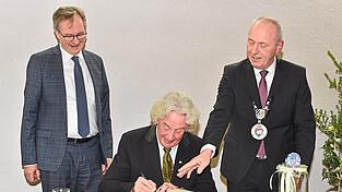 Anlässlich der Verleihung der Ehrenbürgerrechte trug sich 2023 Dr. Ernst Pöschl ins Goldene Buch ein. Das Bild zeigt außerdem Bürgermeister Josef Reff (rechts) und dessen Stellvertreter Siegfried Kaschel.