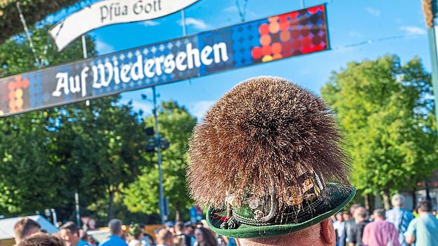 Pfüa Gott: Ein Besucher zeigt sich mit traditionellem Trachenhut auf der Wiesn. Pfüa Gott: Ein Besucher zeigt sich mit traditionellem Trachenhut auf der Wiesn.