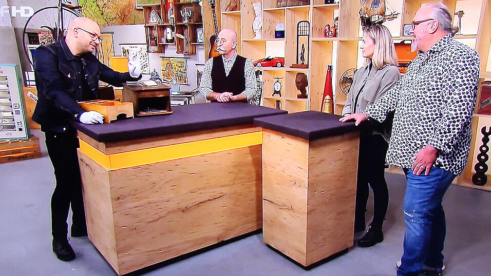 Am Expertentisch erfuhren Joseph und Carolina Berglehner (r.) aus Erding von Kunstexperte Sven Deutschmanek (l.) alles &uuml;ber ihre Kasse. Moderator Horst Lichter (M.) &uuml;berreichte die H&auml;ndlerkarte.