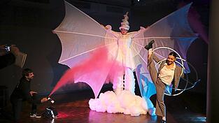 Die dreidimensionale Traumfabrik-Wappenfigur verkörpert Kathrin Klaus. Ingo Pawelke (links unten) sprüht für die Fotografen violetten Rauch, die Artistin La Popi (rechts) beeindruckt mit Hula-Hoop-Kunst. Die dreidimensionale Traumfabrik-Wappenfigur verkörpert Kathrin Klaus. Ingo Pawelke (links unten) sprüht für die Fotografen violetten Rauch, die Artistin La Popi (rechts) beeindruckt mit Hula-Hoop-Kunst.