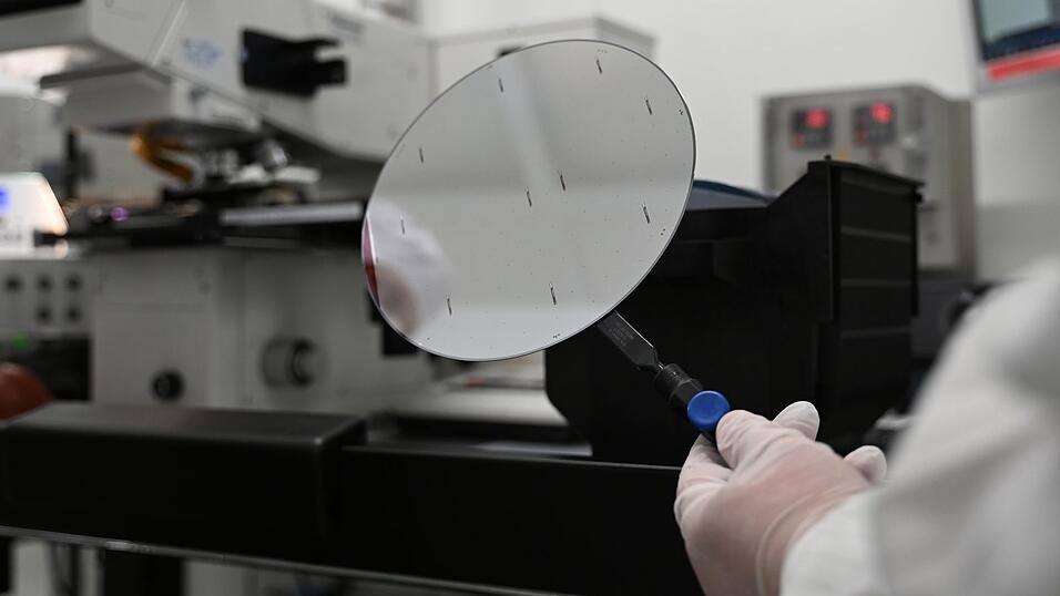 Ein Mitarbeiter der Nexperia Germany GmbH hält ein Zwischenprodukt der Halbleiterproduktion, einen sogenannten Wafer, in den Räumlichkeiten des Halbleiterproduzenten Nexperia mit einer Pinzette fest. Ein Mitarbeiter der Nexperia Germany GmbH hält ein Zwischenprodukt der Halbleiterproduktion, einen sogenannten Wafer, in den Räumlichkeiten des Halbleiterproduzenten Nexperia mit einer Pinzette fest.