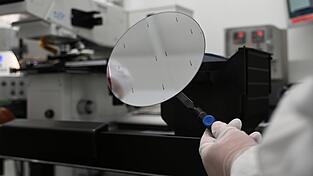 Ein Mitarbeiter der Nexperia Germany GmbH hält ein Zwischenprodukt der Halbleiterproduktion, einen sogenannten Wafer, in den Räumlichkeiten des Halbleiterproduzenten Nexperia mit einer Pinzette fest. Ein Mitarbeiter der Nexperia Germany GmbH hält ein Zwischenprodukt der Halbleiterproduktion, einen sogenannten Wafer, in den Räumlichkeiten des Halbleiterproduzenten Nexperia mit einer Pinzette fest.