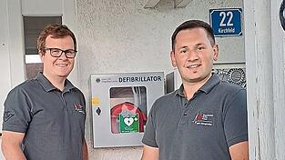 Stefan Aufschläger und Klaus Daiminger zeigen den öffentlich zugänglichen Früh-Defibrillator beim Vereinsheim in Martinsbuch und ermutigen die Bevölkerung dazu, ihn im Ernstfall einzusetzen. 'Denn auf den Einsatz durch Laien ist er ausgelegt', so die HVOler.
