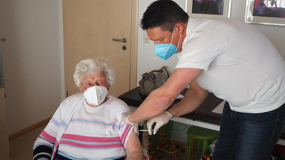 Dr. Andreas J&ouml;rg impft in seiner Praxis die erste Patientin.