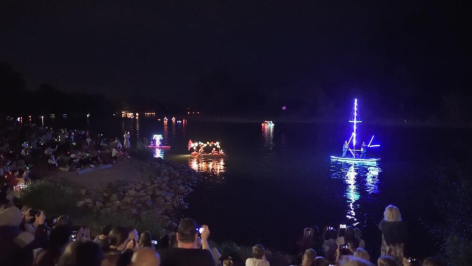 Bunt beleuchtete Boote fahren bei der Lampionfahrt über die Donau.