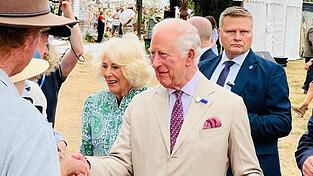 Da sind sie: König Charles und Königin Camilla gehen mit freundlichem Lächeln die Reihe der Wartenden ab. Da sind sie: König Charles und Königin Camilla gehen mit freundlichem Lächeln die Reihe der Wartenden ab.