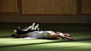 Daggi Gusenbauer legt sich flach auf den Boden, Hope bettet sich auf ihren Bauch und streckt alle Vieren von sich.