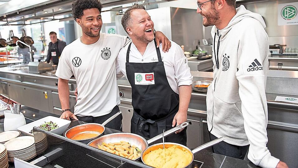 Hautnah an den Stars: Anton Schmaus mit Serge Gnabry (l.) und Jonas Hector (r.) in der Küche. Hautnah an den Stars: Anton Schmaus mit Serge Gnabry (l.) und Jonas Hector (r.) in der Küche.