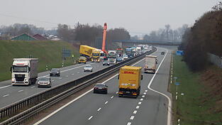 Der Mobilkran bringt sich für die Bergung in Position. Mit schwerem Gerät soll der umgekippte Anhänger gedreht und zurück auf die Fahrbahn gehoben werden. Der Mobilkran bringt sich für die Bergung in Position. Mit schwerem Gerät soll der umgekippte Anhänger gedreht und zurück auf die Fahrbahn gehoben werden.