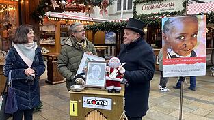Mathis Winkler (Mitte) &uuml;berreichte Drehorgelspieler Josef Neumaier ein Bild als Dankesch&ouml;n f&uuml;r das gesammelte Geld.